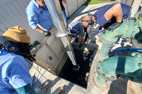 men operating vaccum truck in a sewer pipe